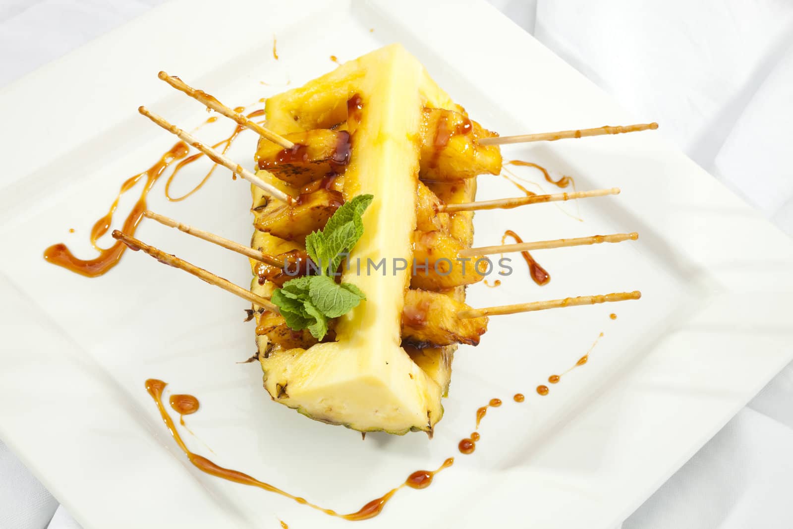 Grilled ananas with honey and mint leaves
