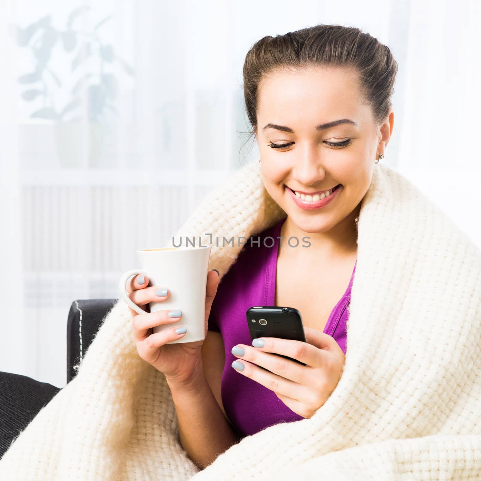 Attractive young brunette woman using her cell phone to send SMS