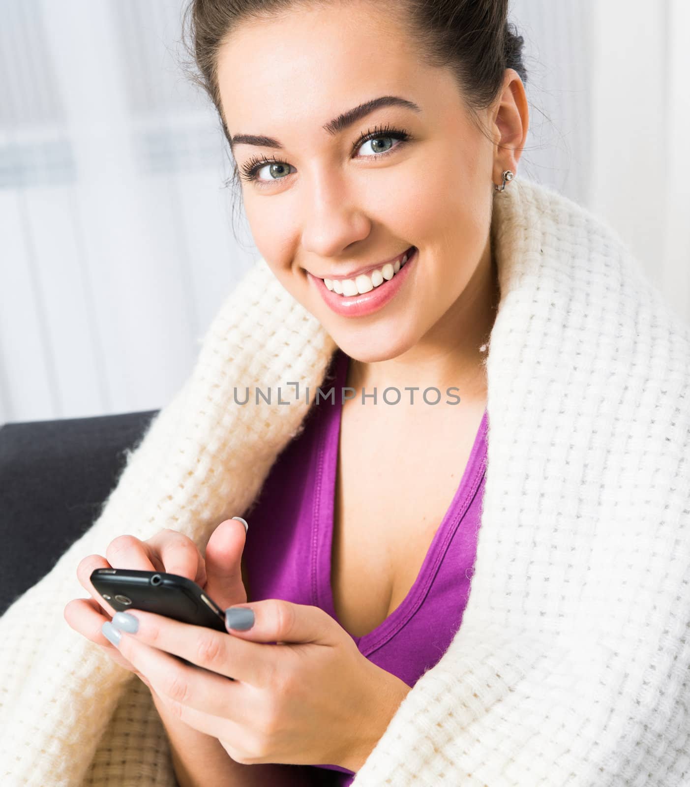 Beautiful brunette woman using her cell phone to send a text message