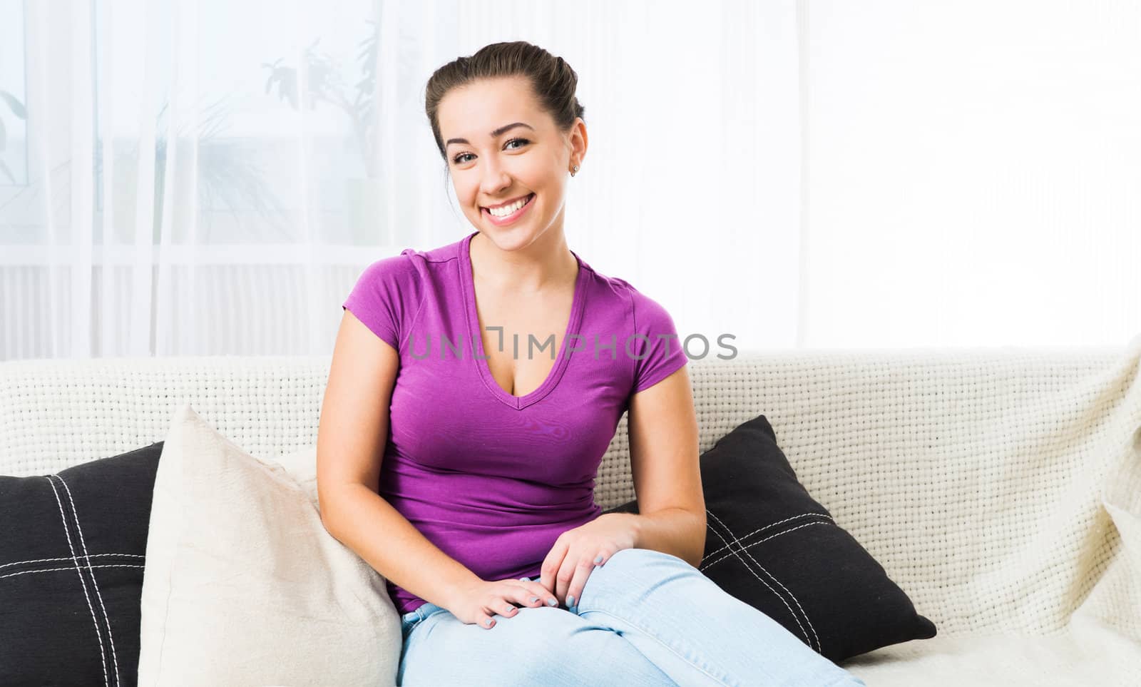 Beautiful young woman sitting on a sofa