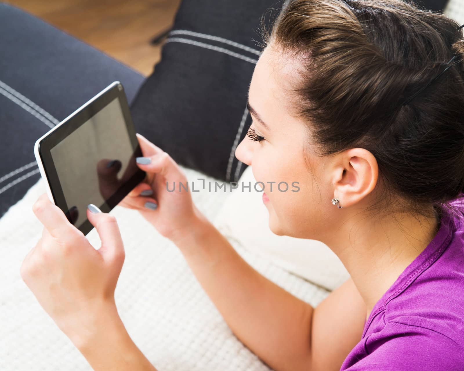 Student girl with tablet pc on the sofa.