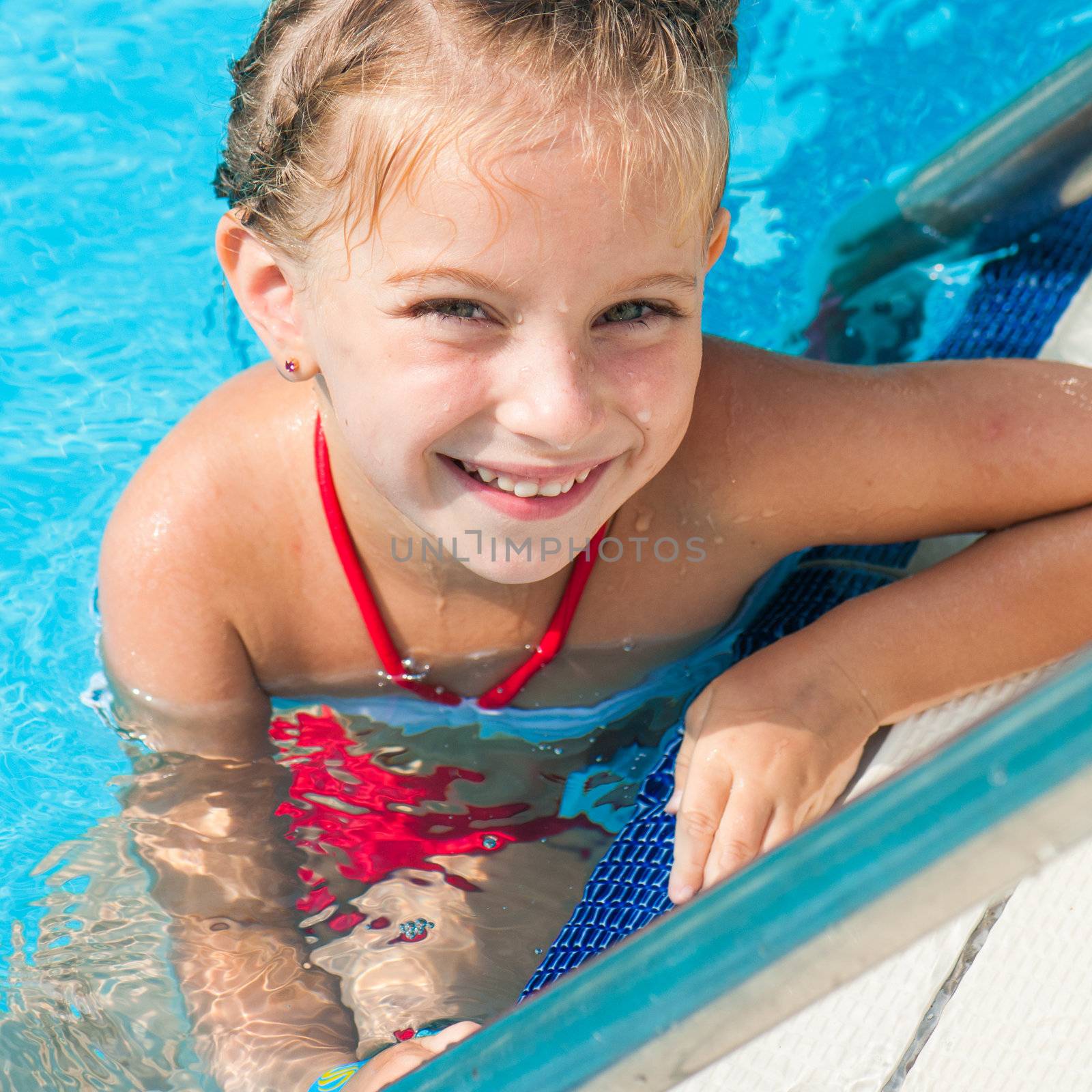 Smiling cute little girl in swimming pool