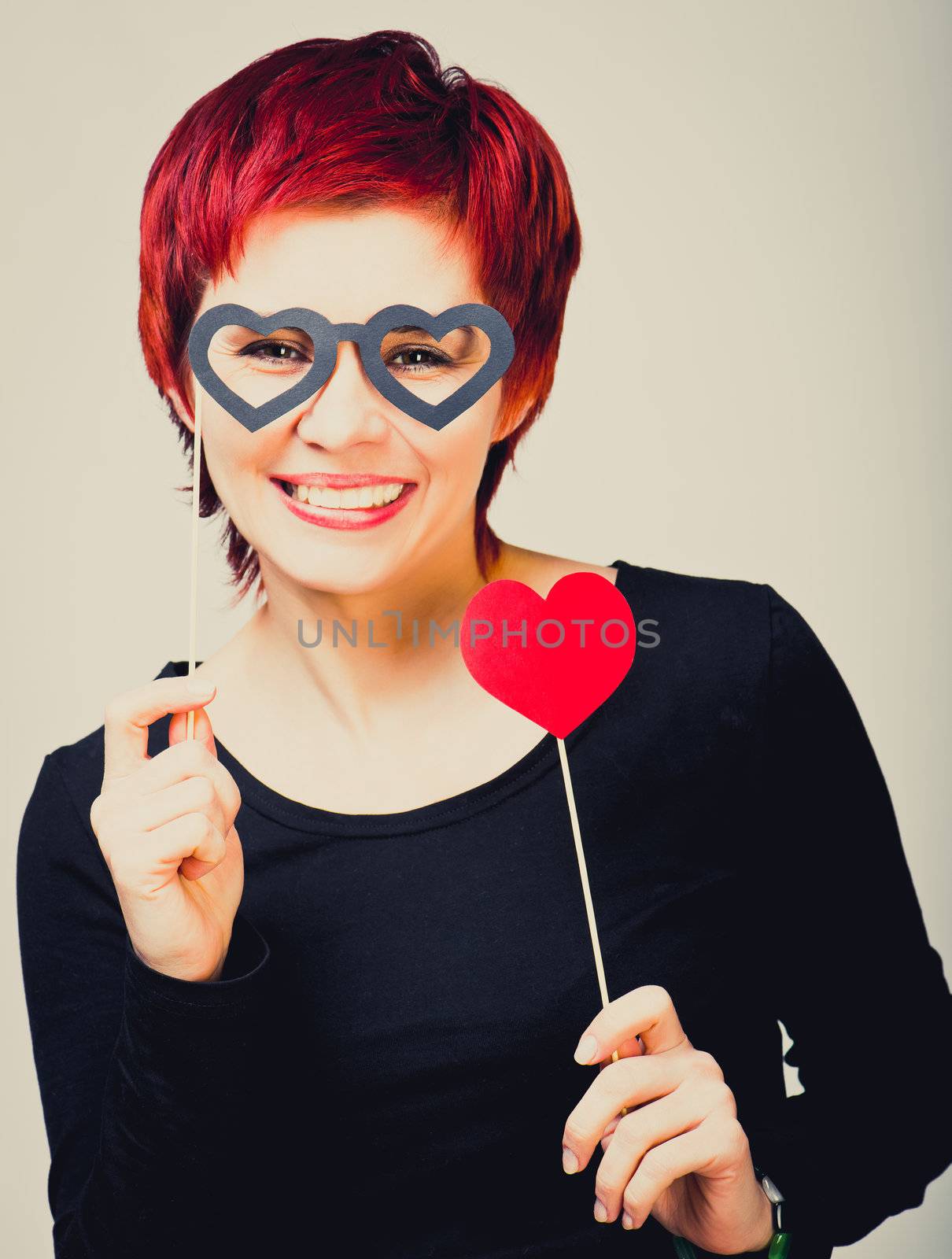 young woman with a red paper heart in glasses