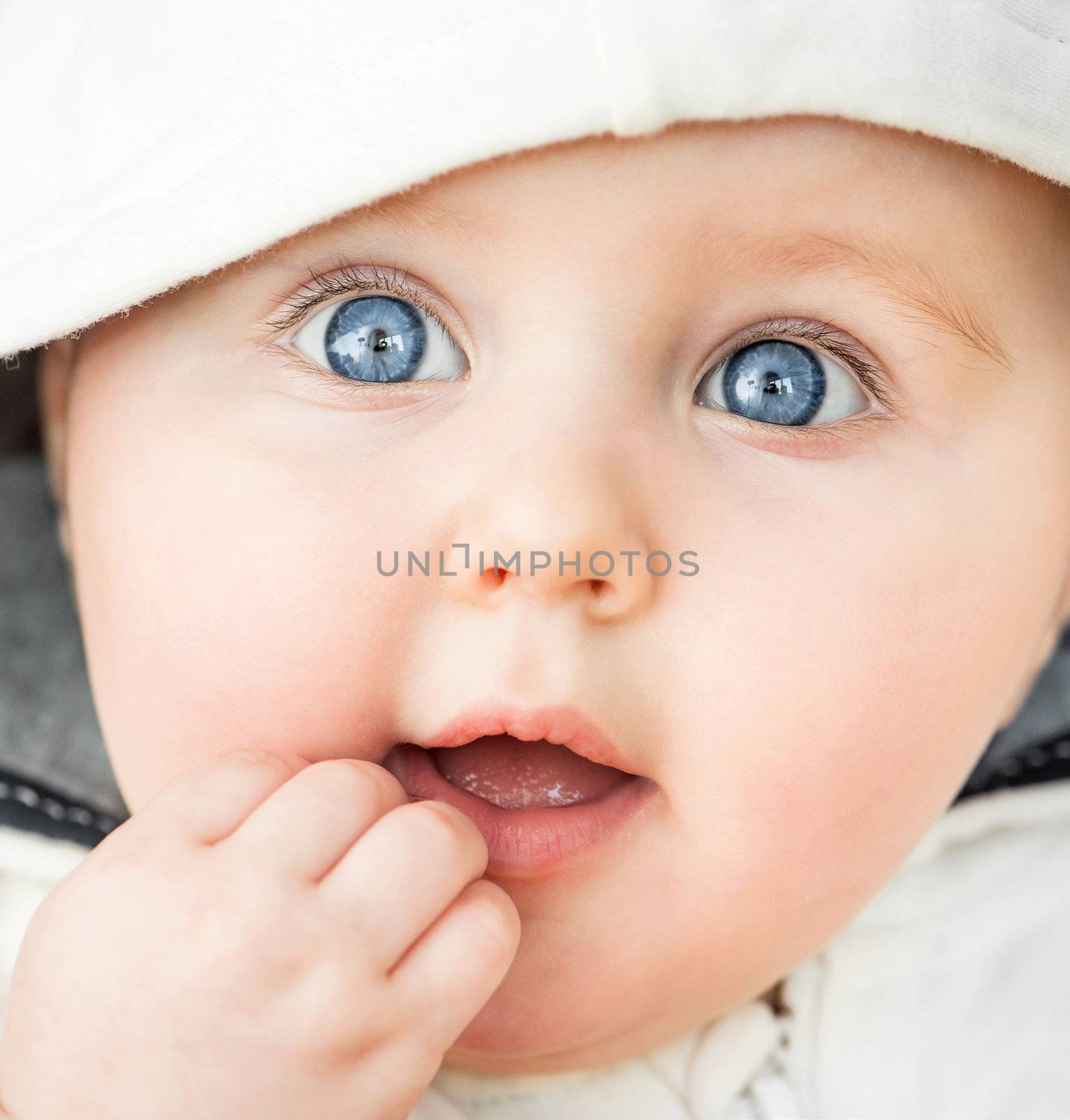 bright closeup portrait of adorable baby in the hood