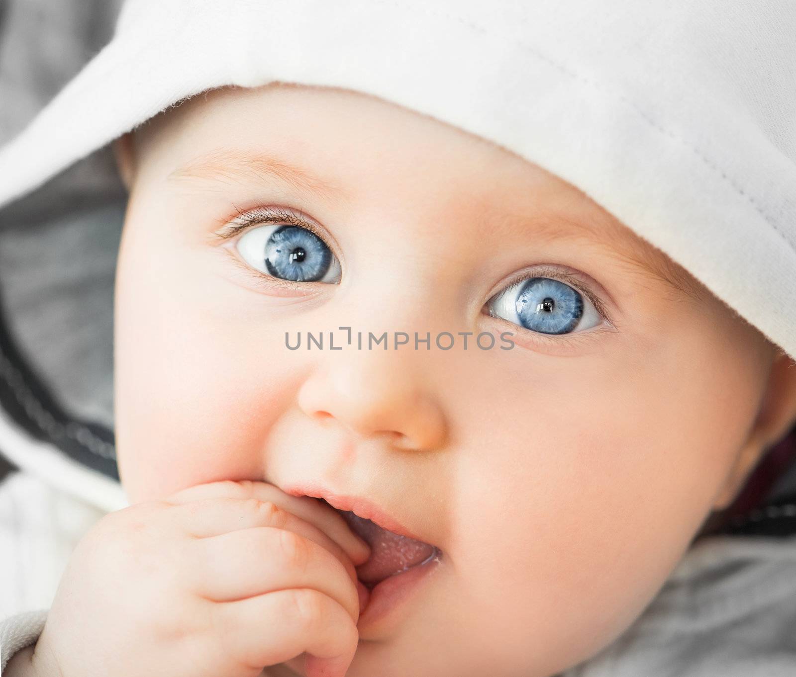 bright closeup portrait of baeutiful baby in the hood