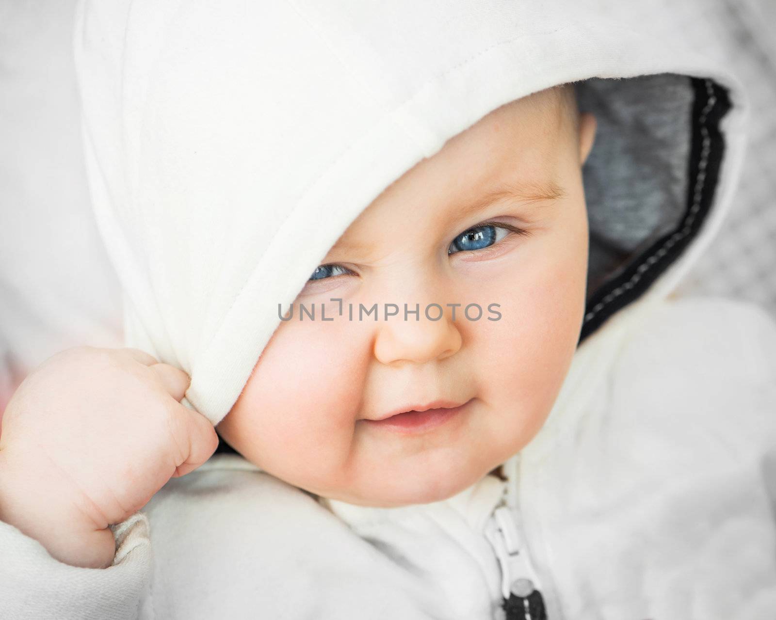 bright closeup portrait of funny adorable baby in the hood