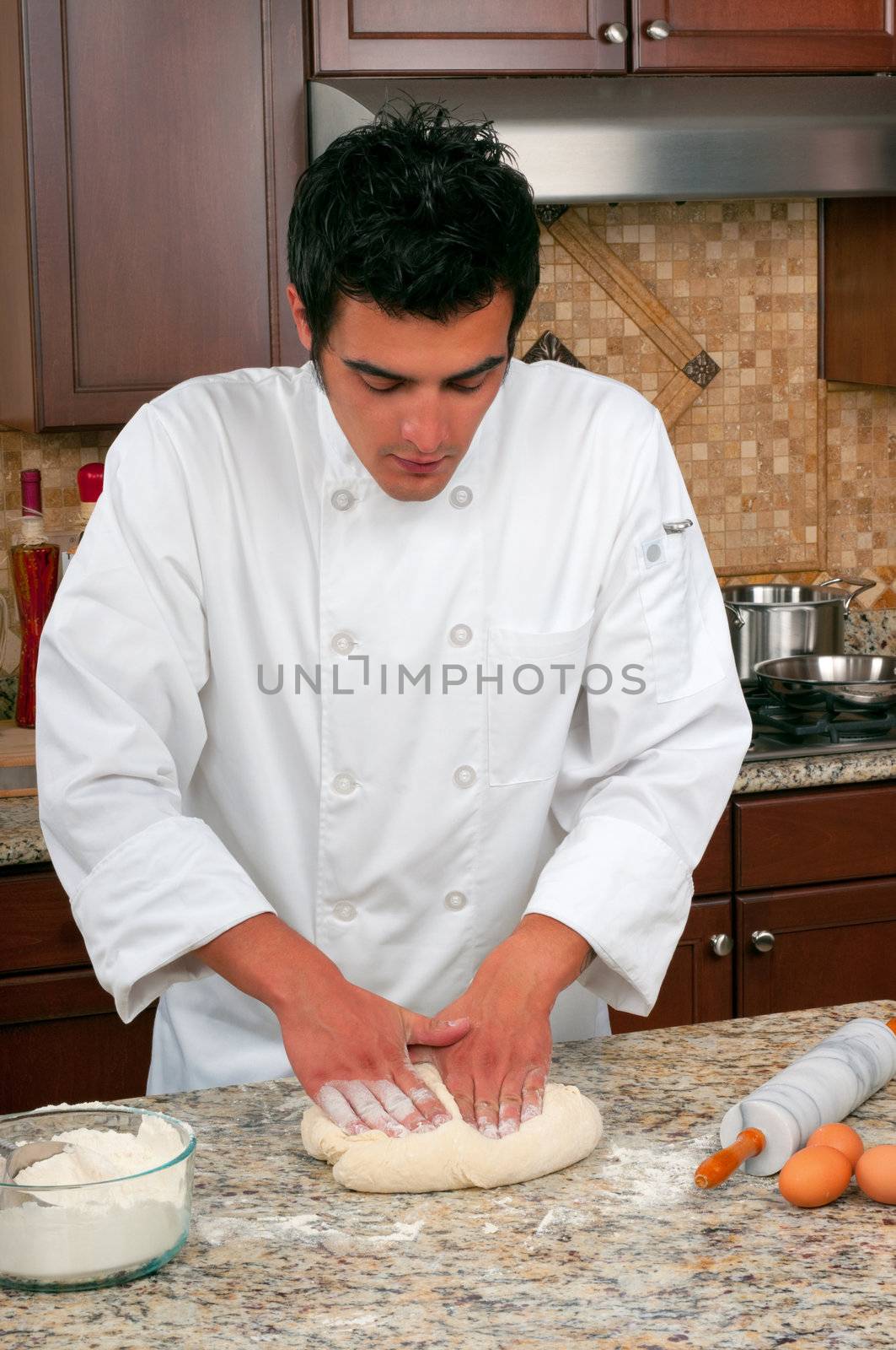 Handsome chef making bread or pasta 