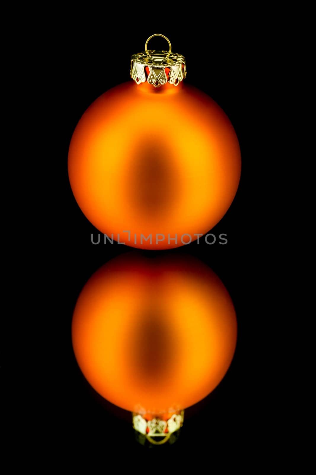 christmas decoration bauble in orange on black background