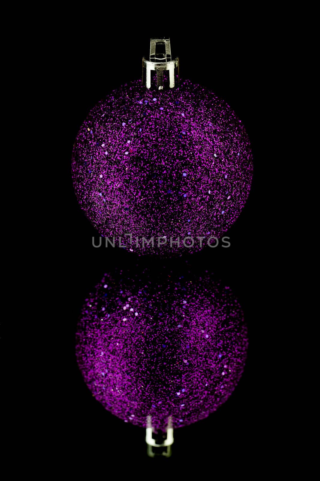 christmas decoration bauble in purple on black background