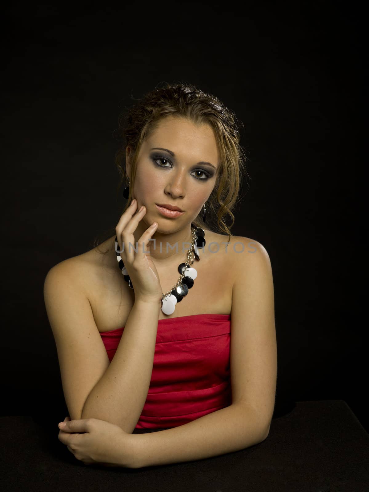 A teen girl wearing a formal dress and an updo on a black background.                                  
Makeup By: Wright Artistry www.wrightartistry.com