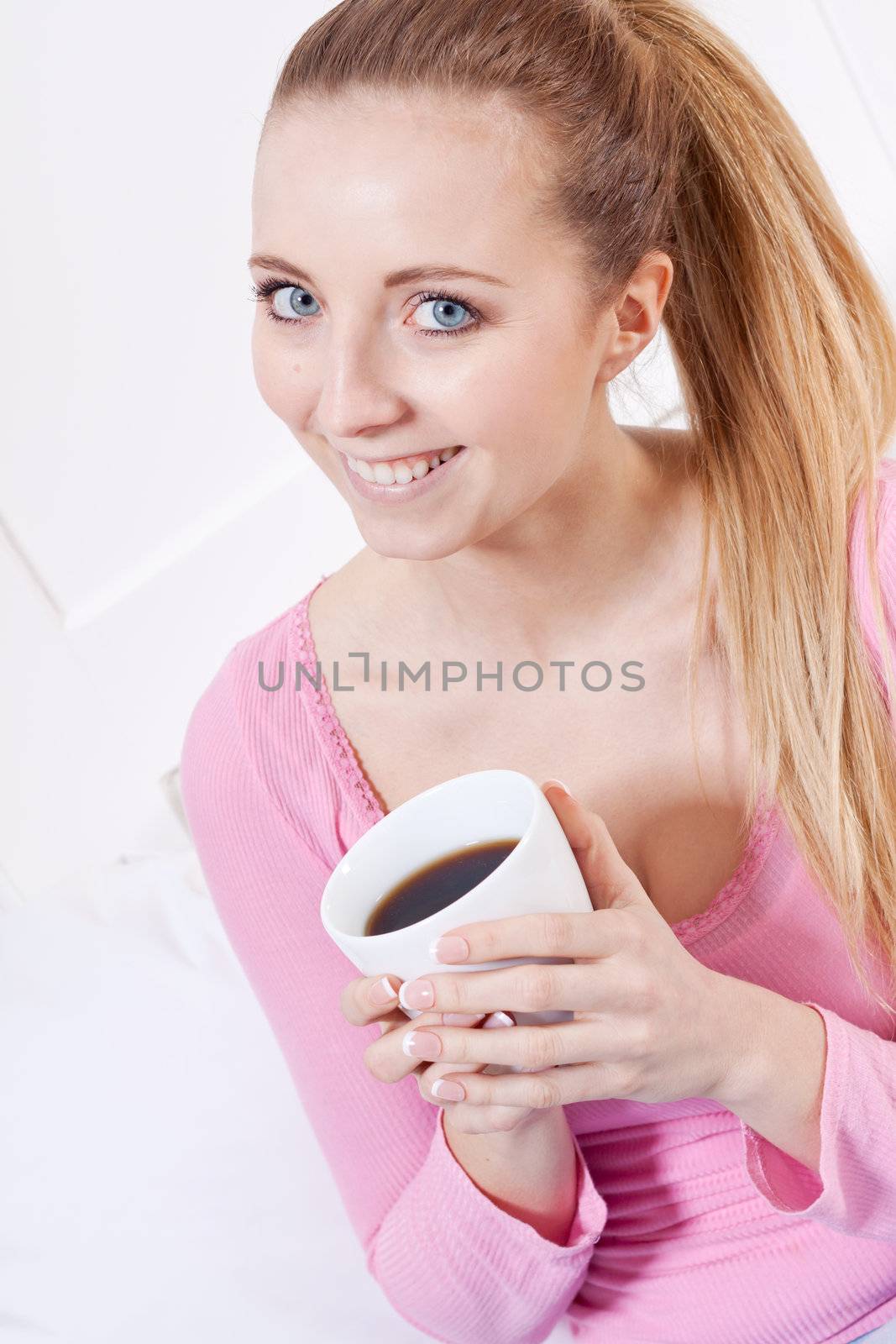 smiling young woman drinking coffee in the morning