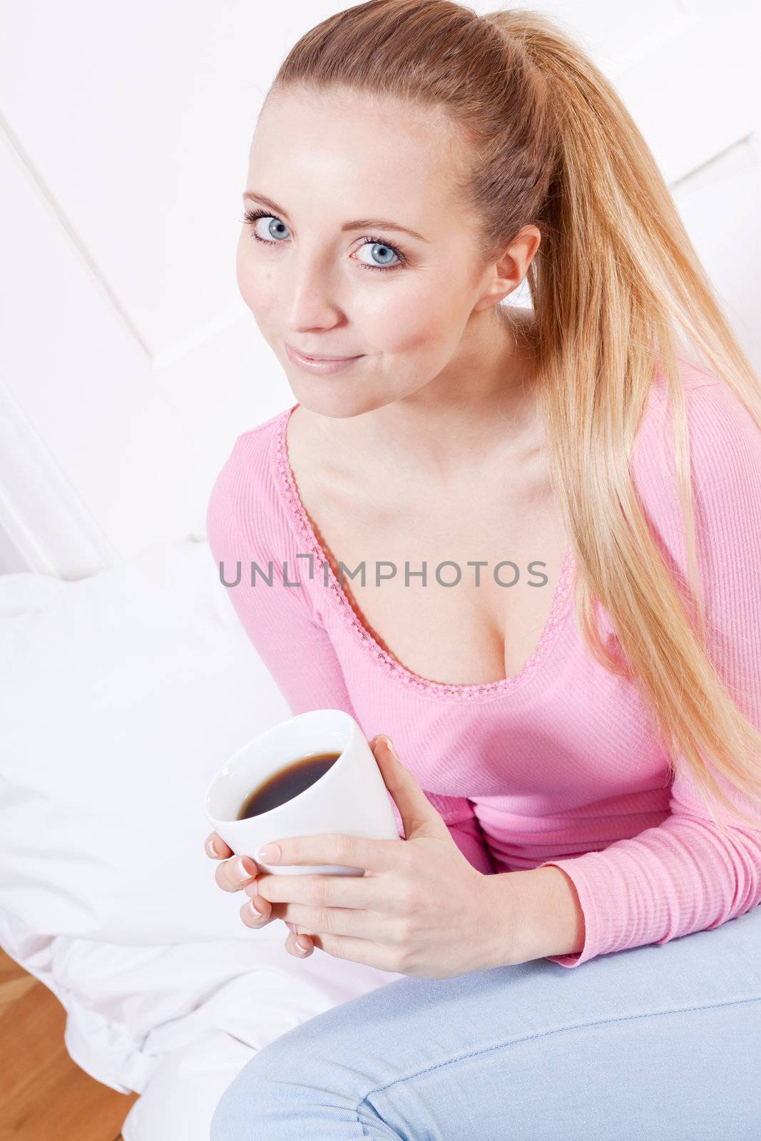smiling young woman drinking coffee in the morning