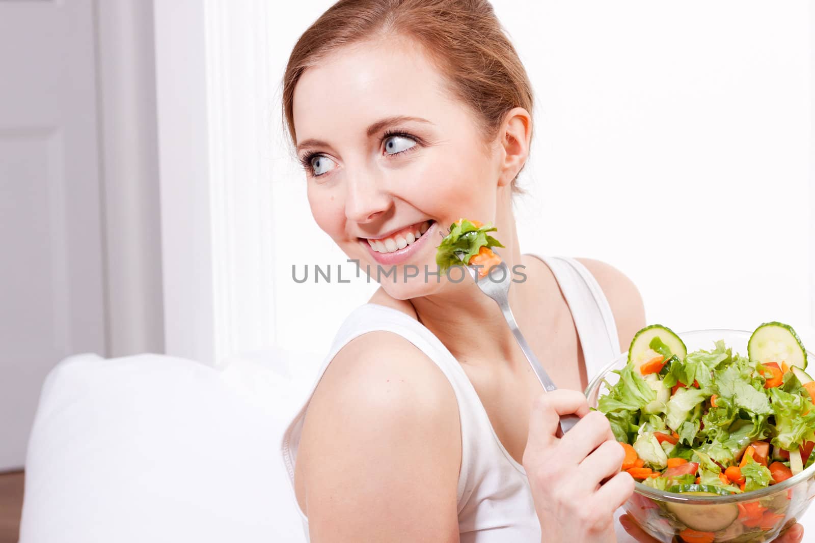 attractive young woman eating fresh healthy salad for lunch