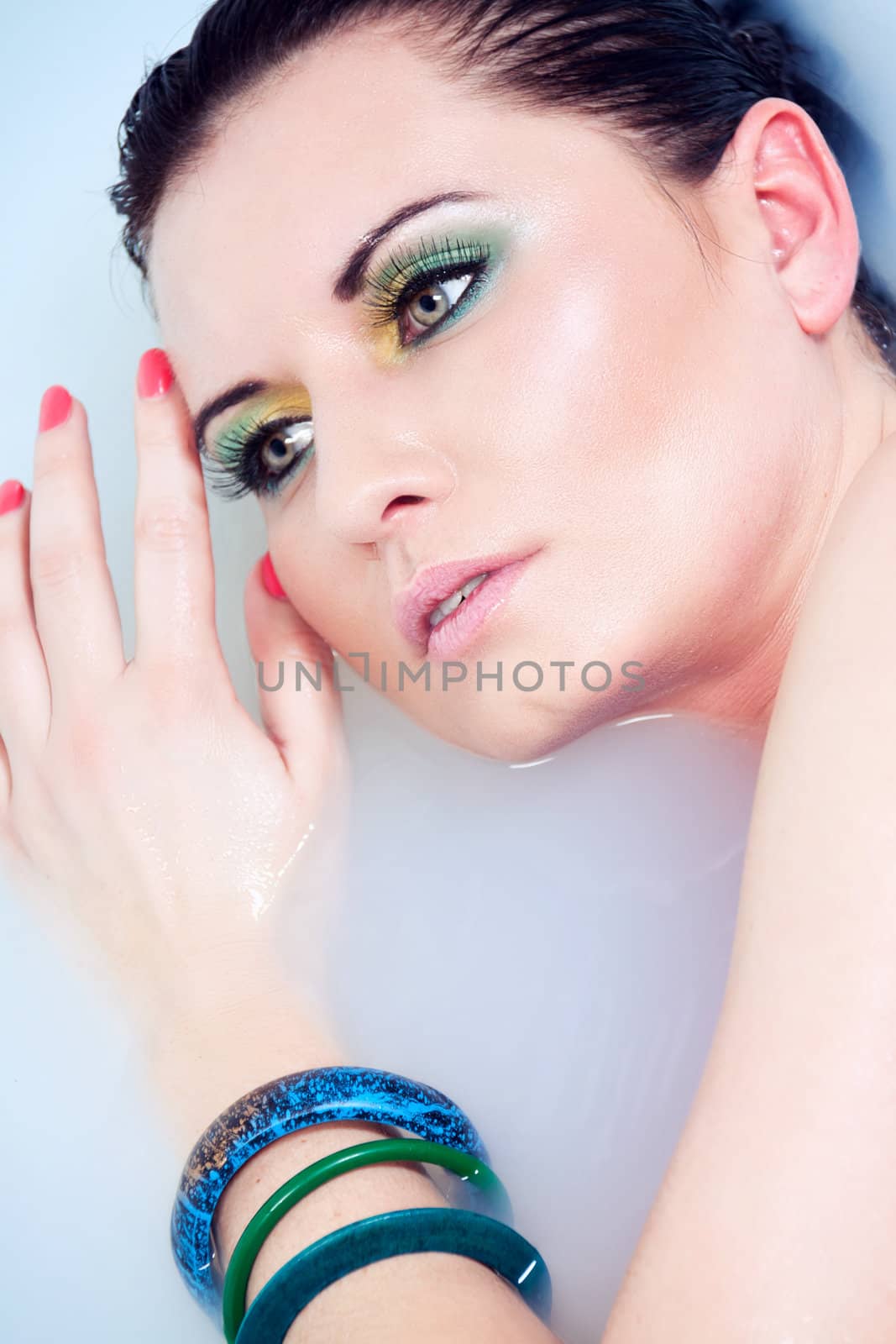 beautiful young woman with colorful makeup in water sexy