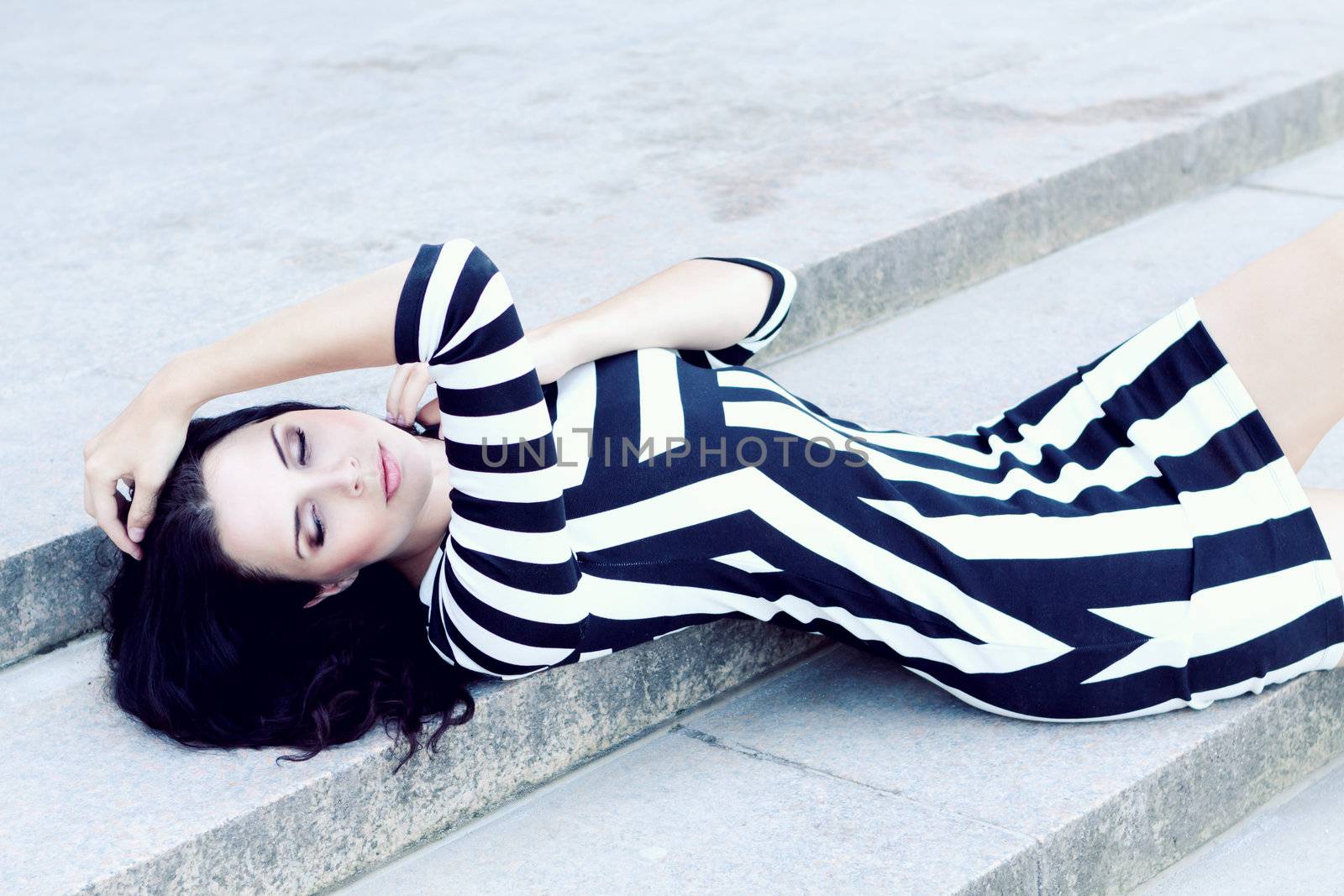 attractive young woman in sexy dress outdoor lying stairs