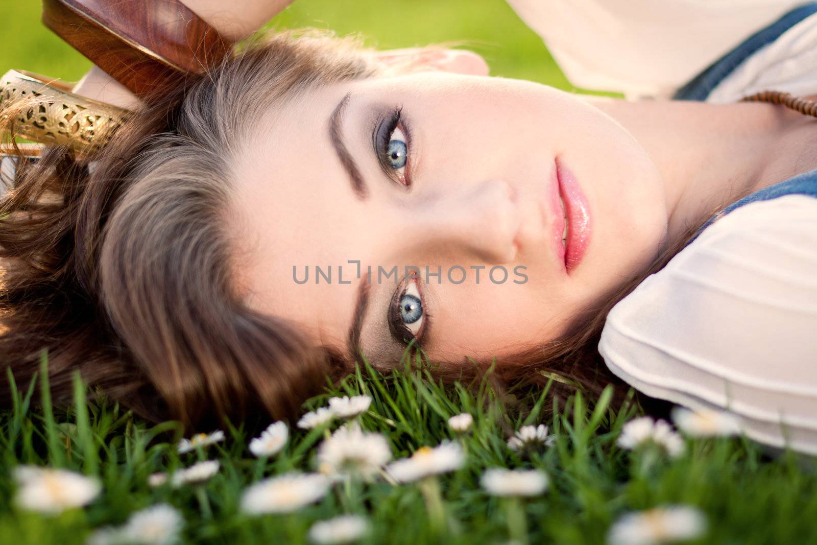 beautiful woman lying in grass with flowers in summer outdoor