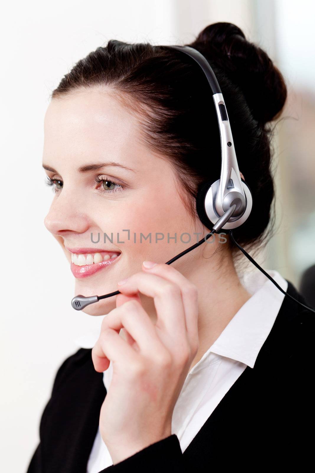 smiling young female callcenter agent with headset in office