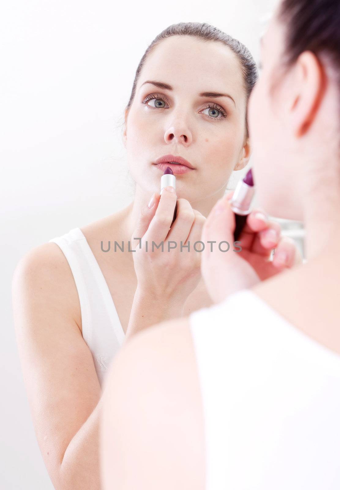 beautiful attractive woman applying cream on face skincare