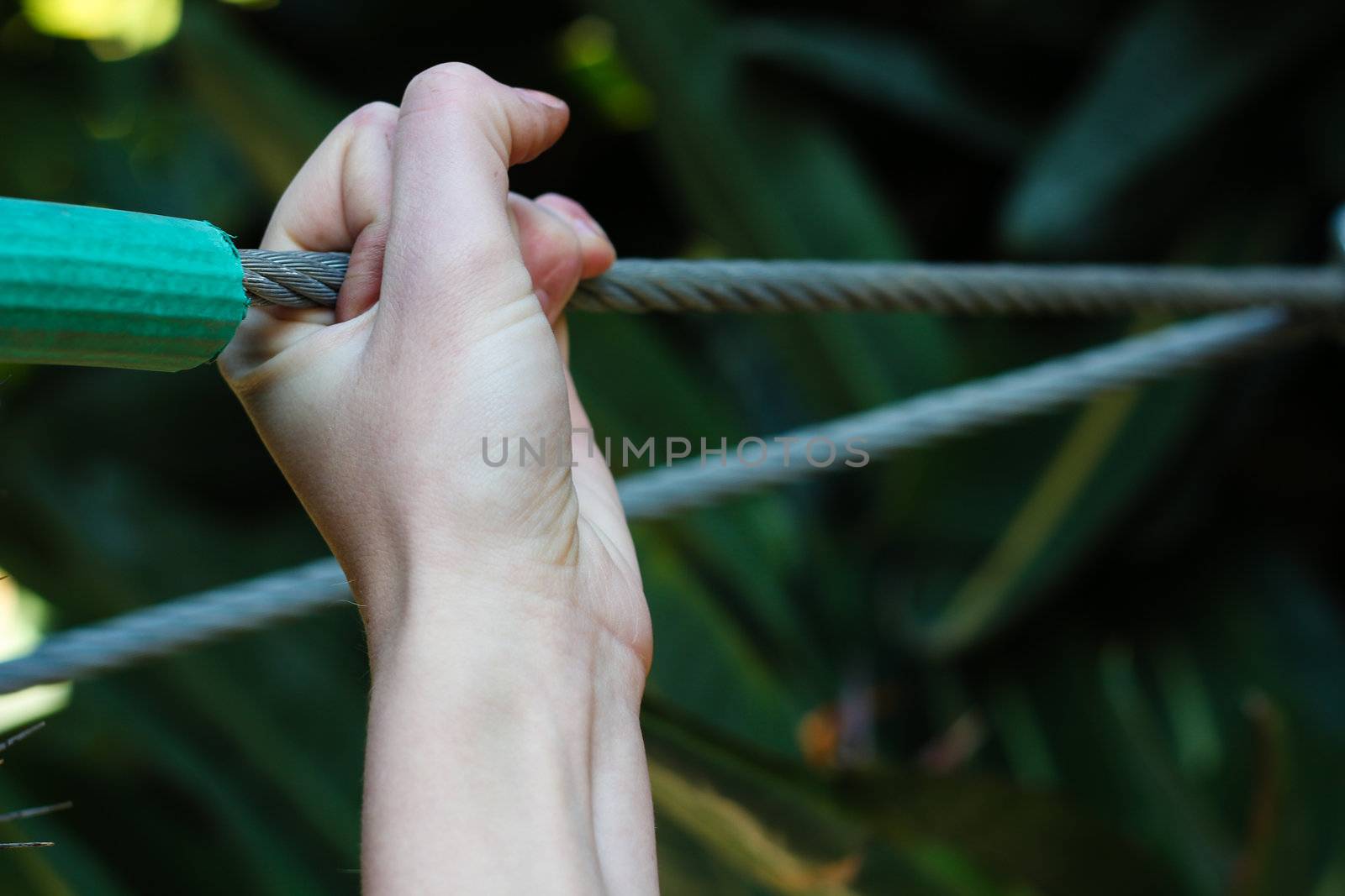 Hand holding onto a Wire cable by dwaschnig_photo