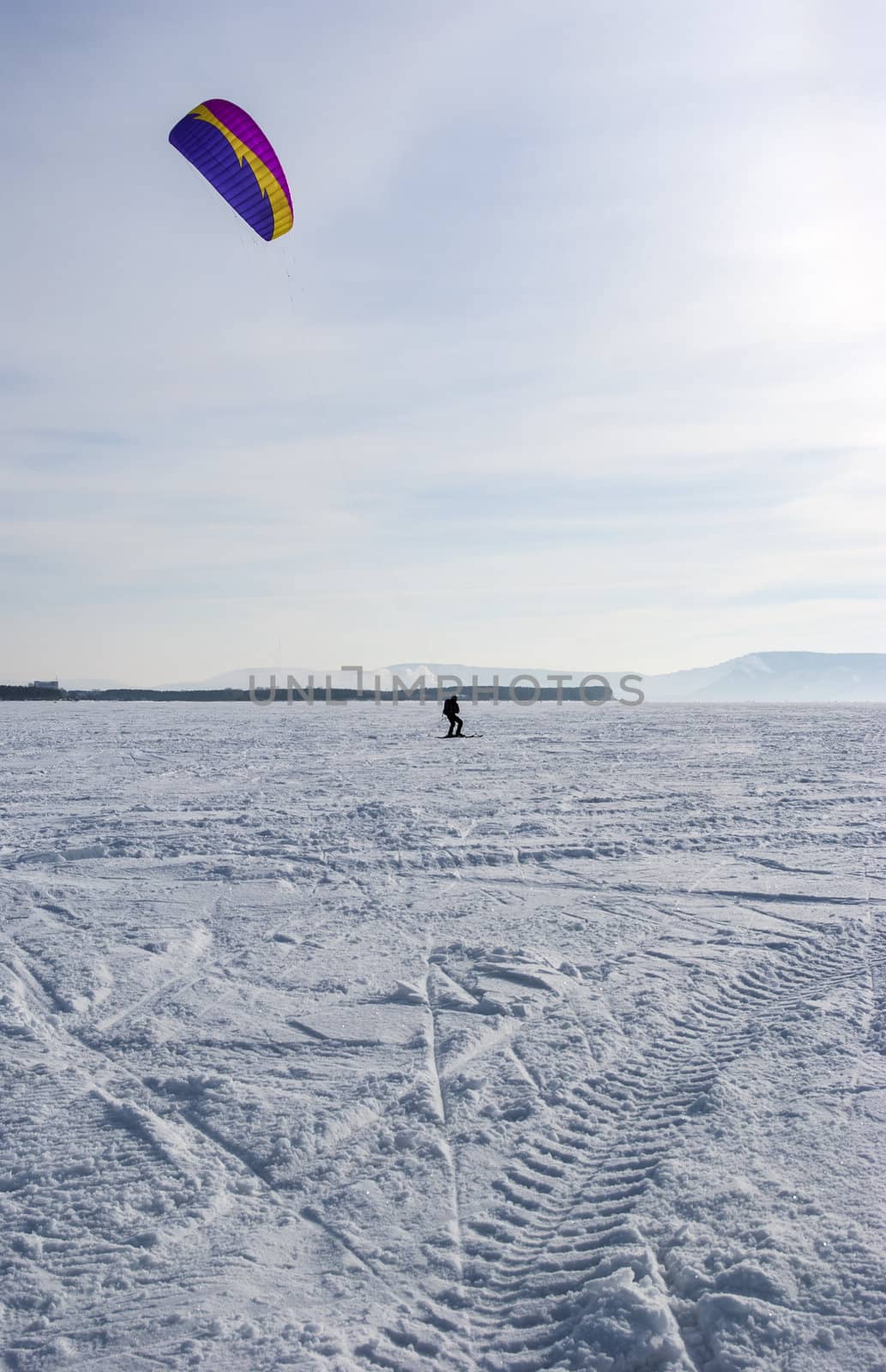 Winter kite skiing on the frozen river