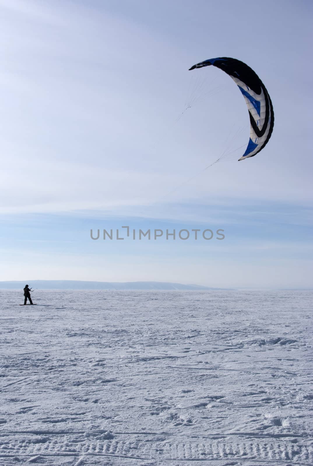 Winter kite skiing on the frozen river