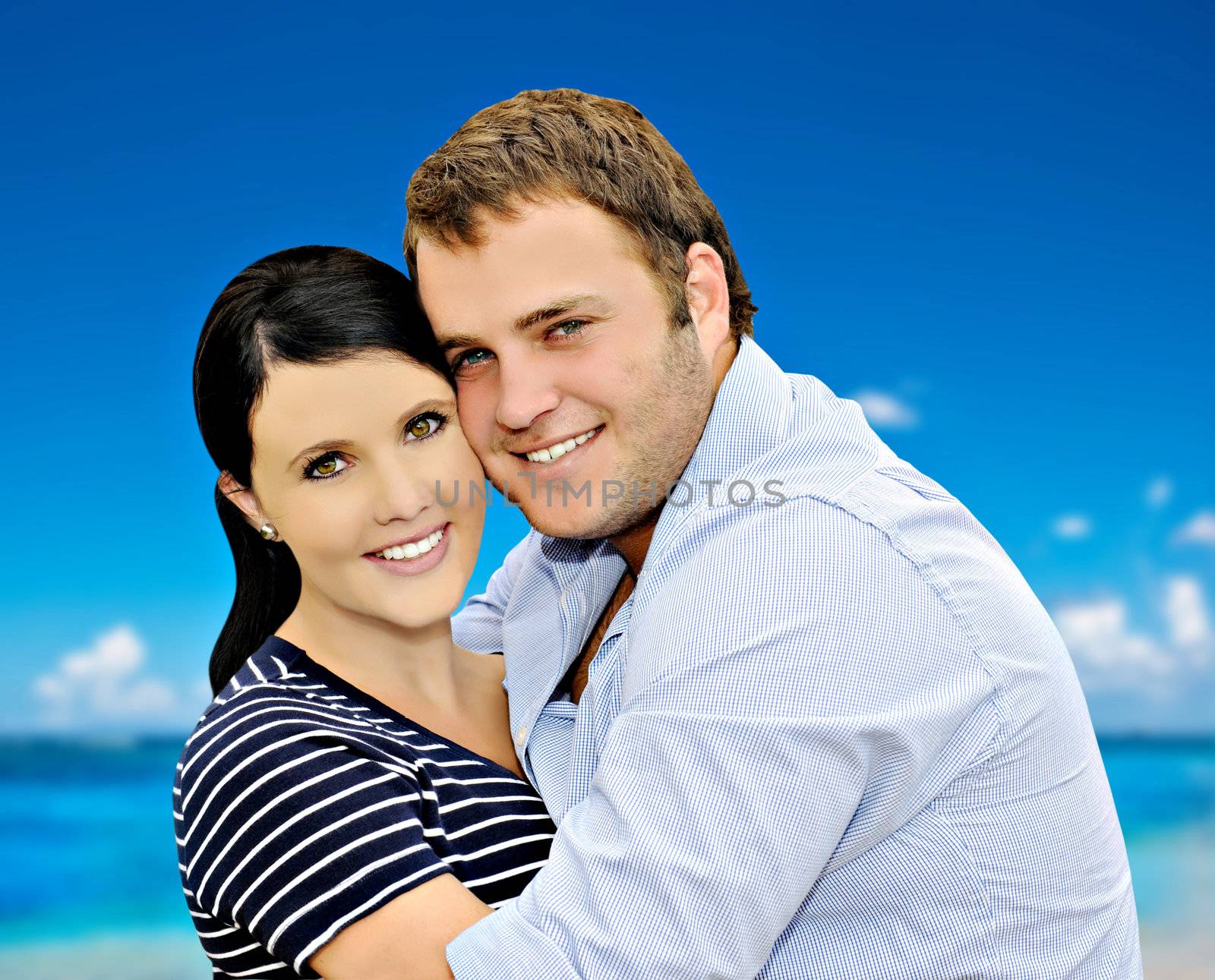 Beautiful young couple with sea and sky in the background