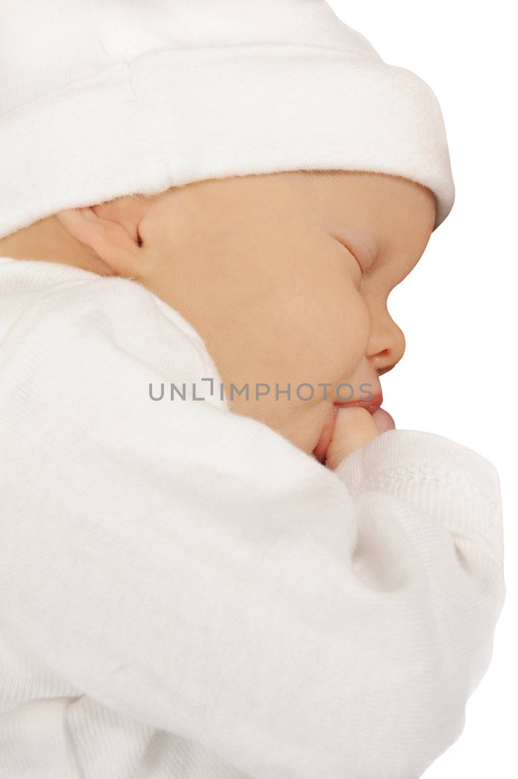 Newborn baby sucking on her thumb on white