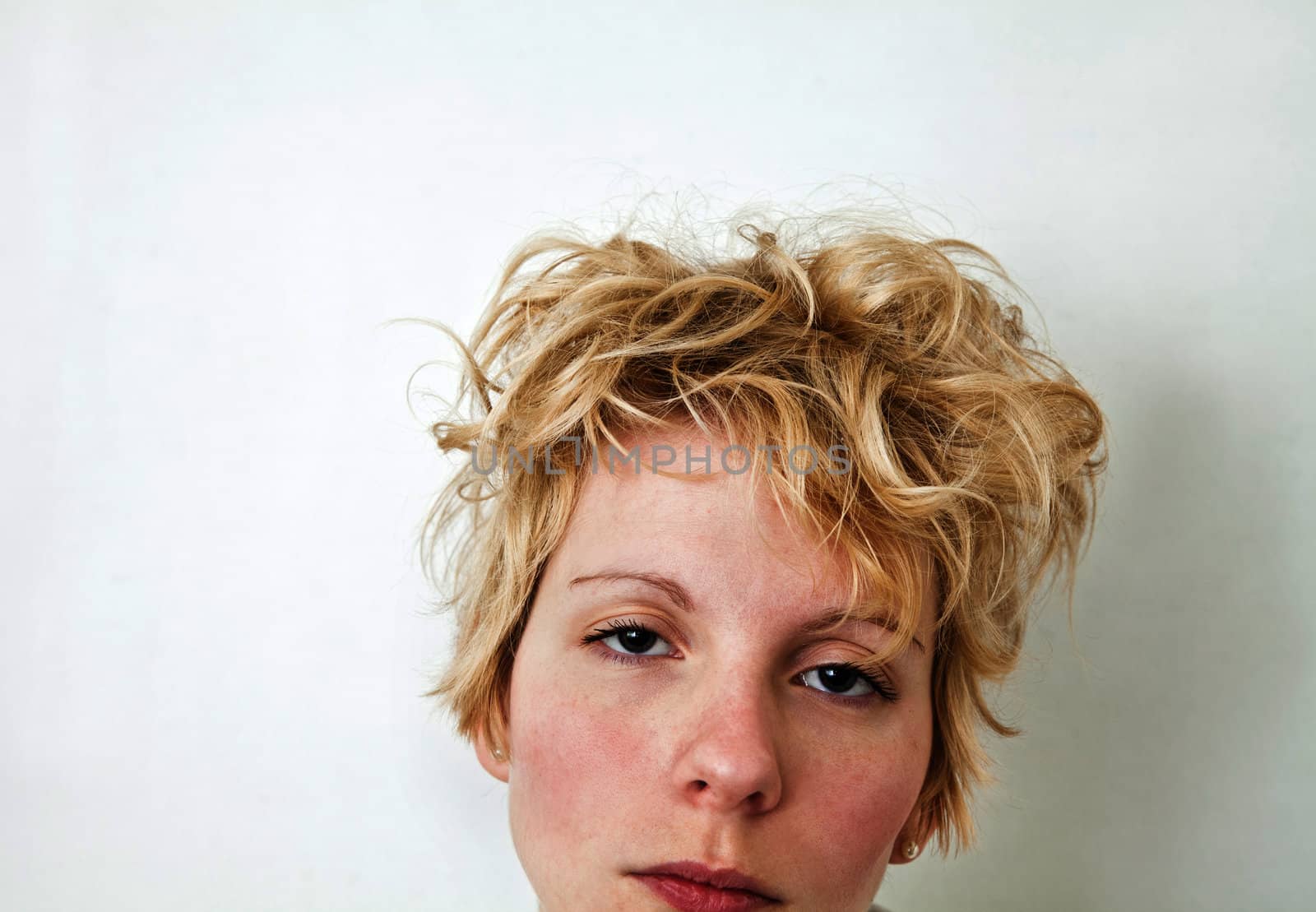 Young blond girl with morning look and mixed hairs on a white background