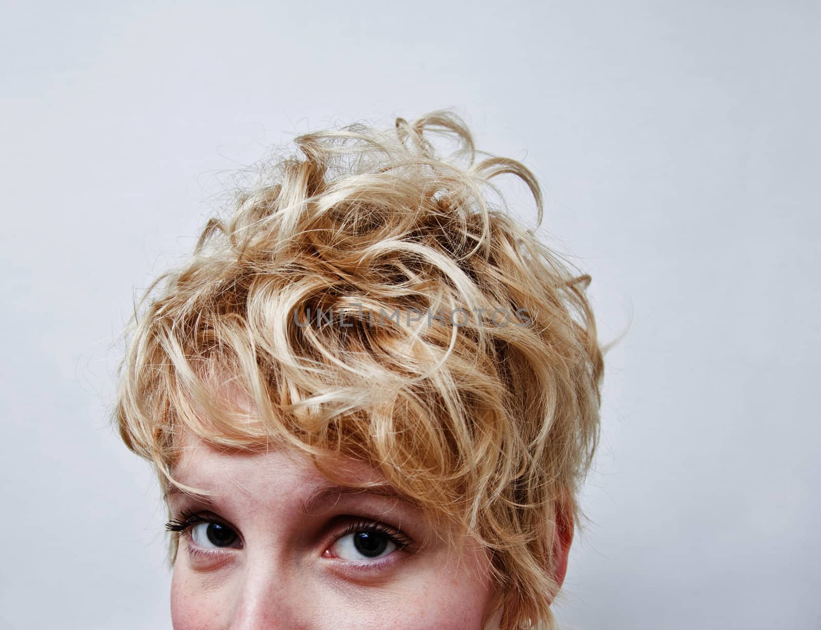 Young blond girl with morning look and mixed hairs on a white background