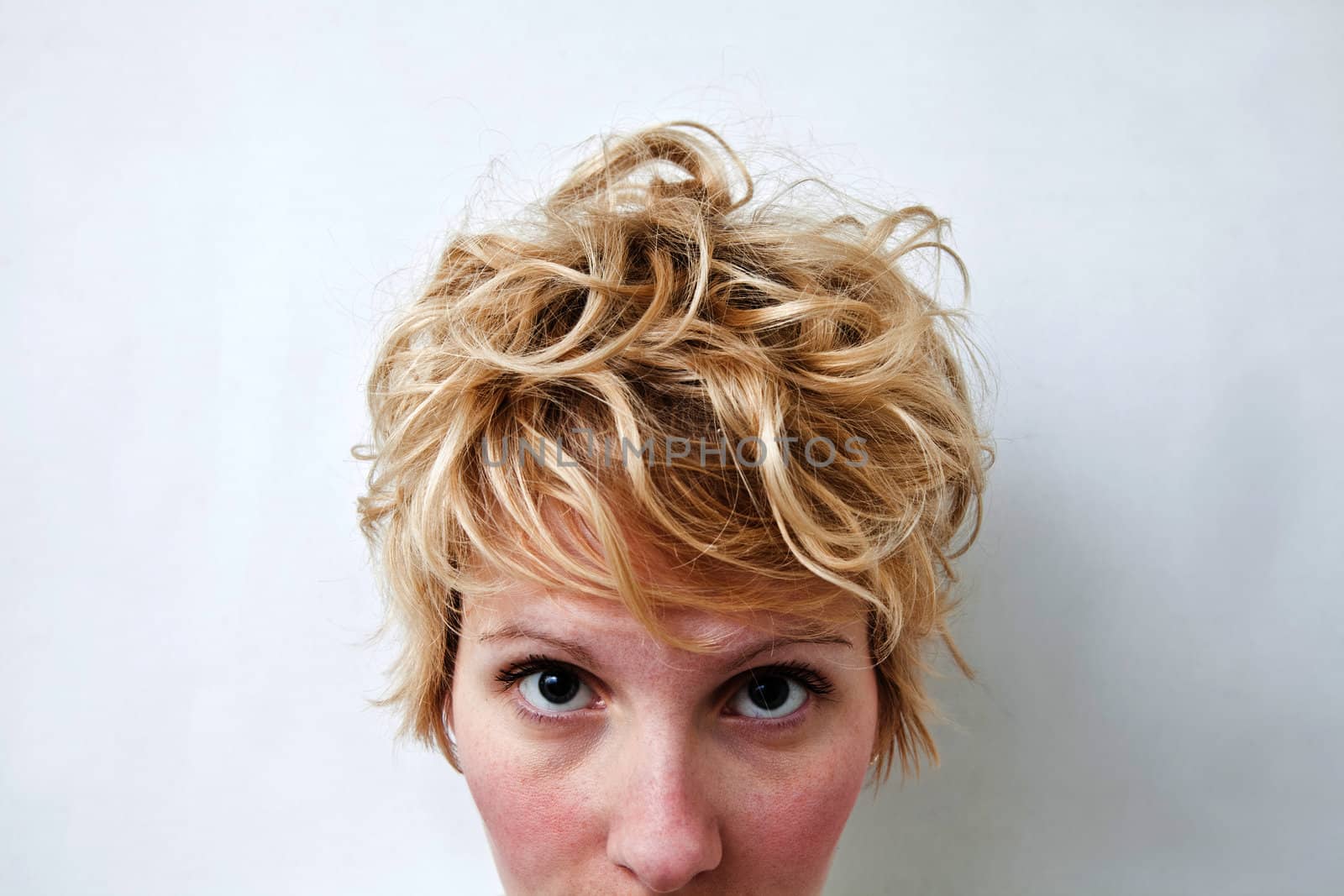 Young blond girl with morning look and mixed hairs on a white background