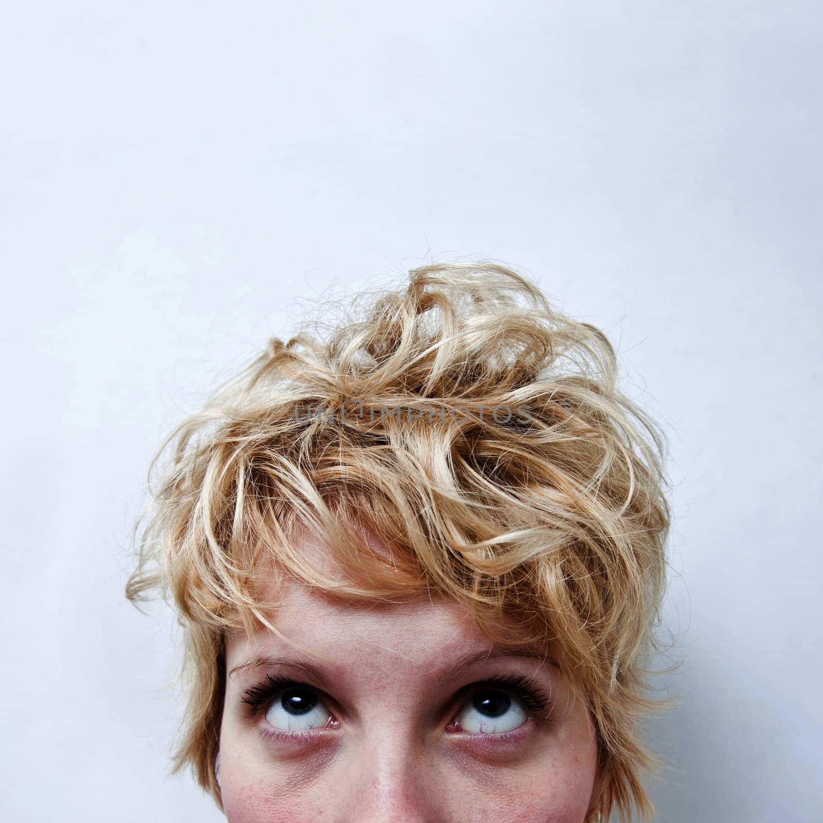 Young blond girl with morning look and mixed hairs on a white background