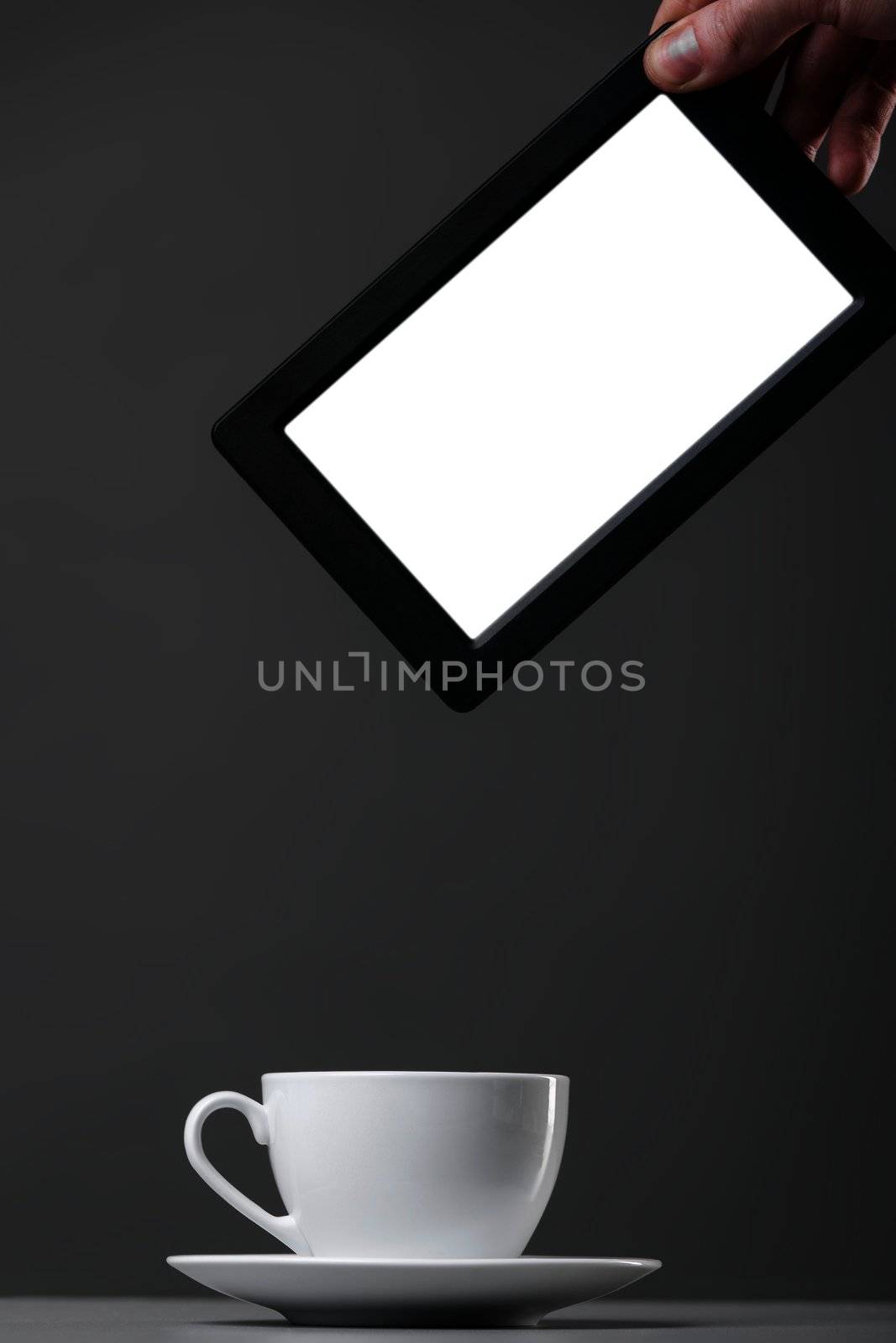 White mug and tablet computer on a gray background.