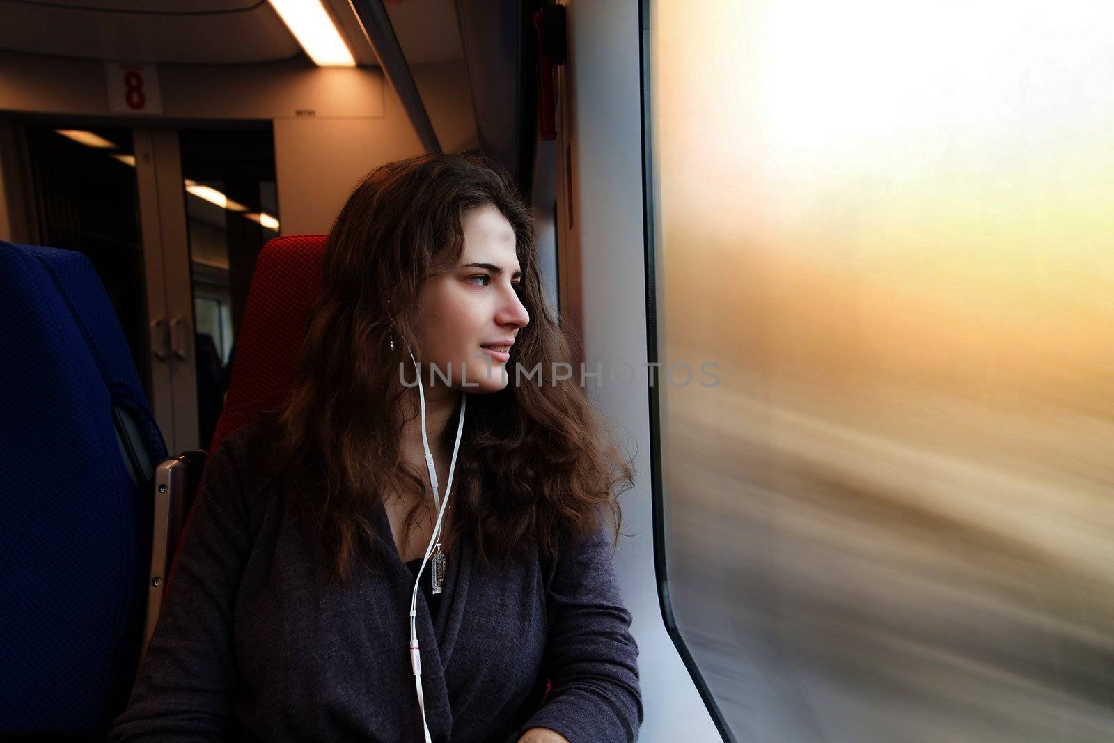 woman looks out the window while sitting in the train.