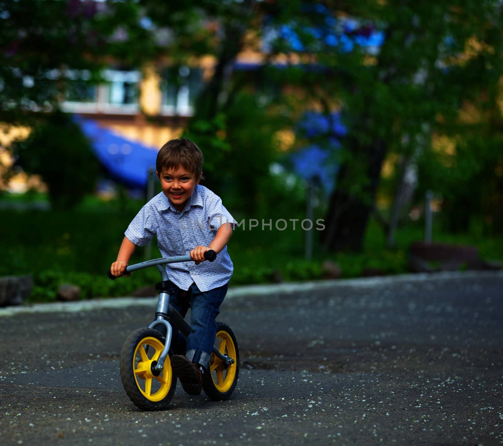 Little boy on a bicycle and his mother in the summer park
