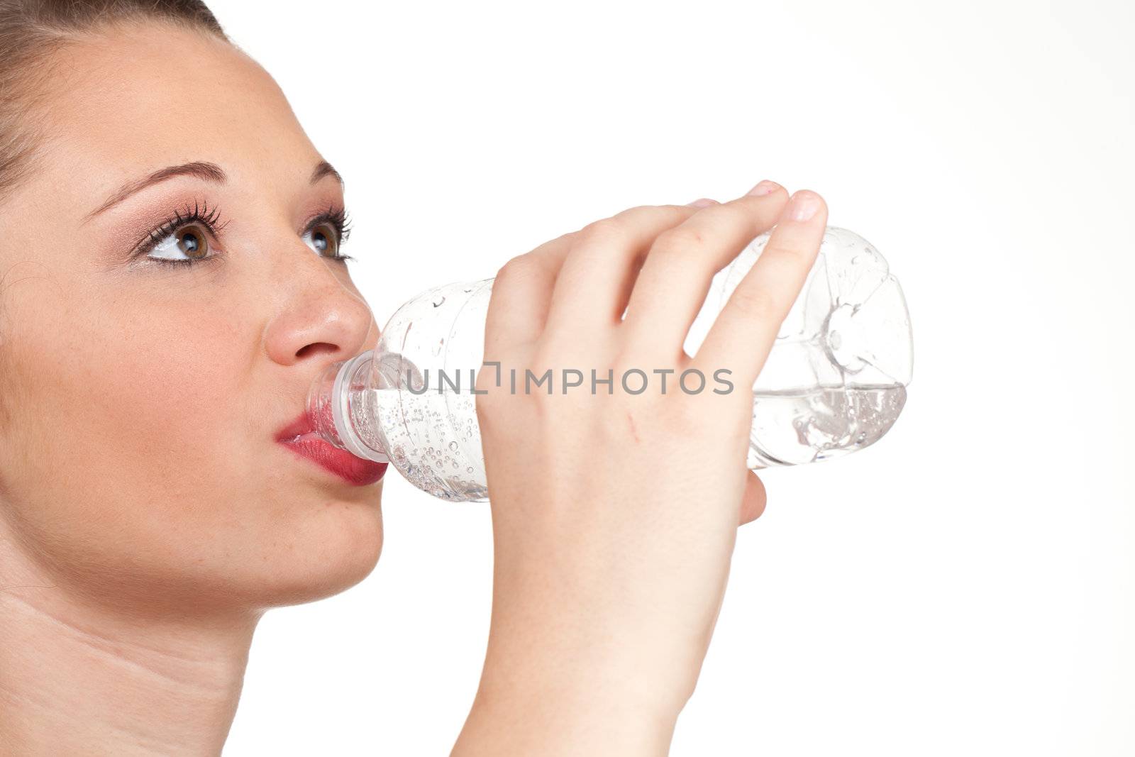 The bottle is emphasised in this head shot drinking studio shot.