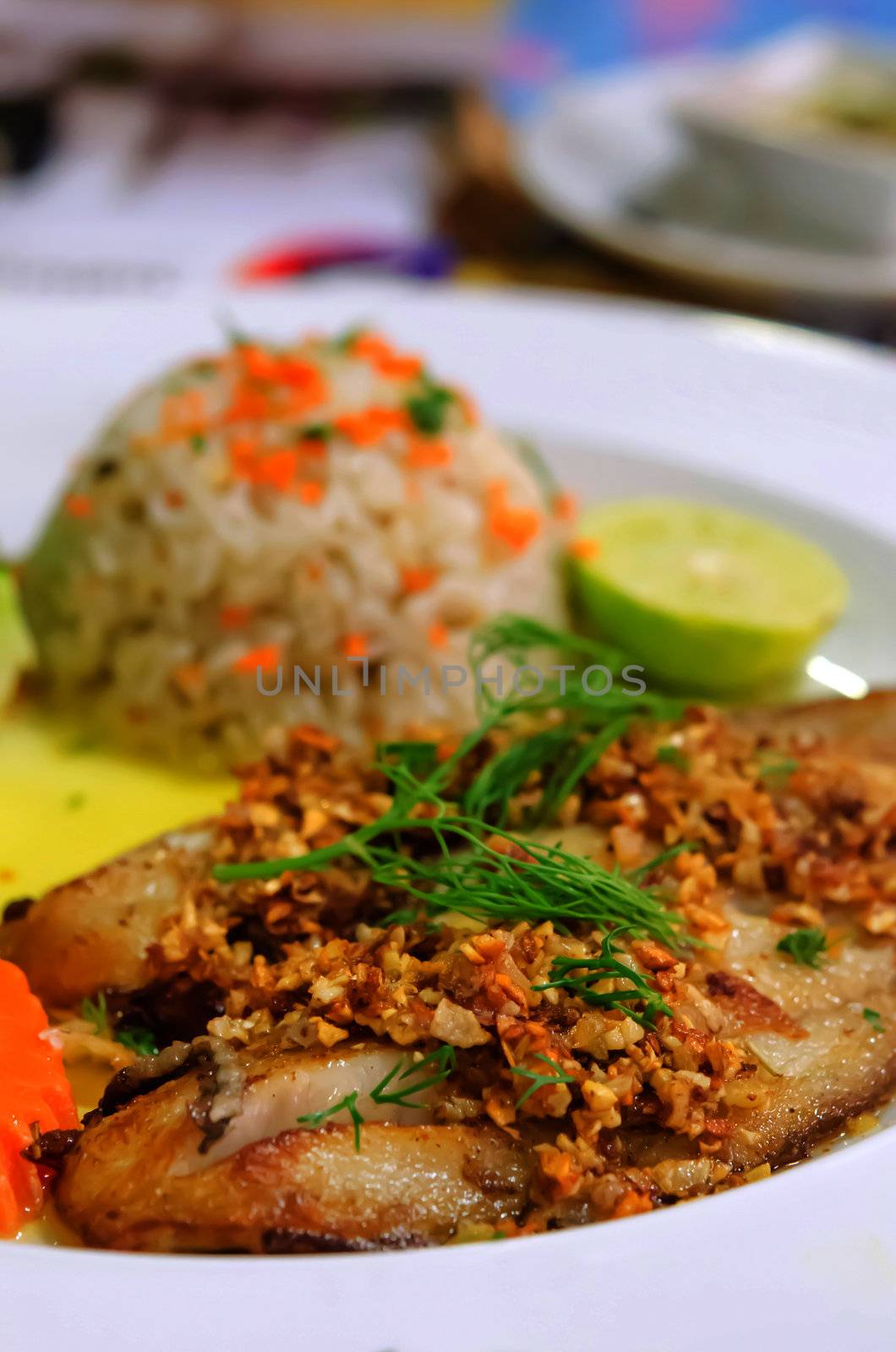 close up fish steak served with fried rice and vegetable