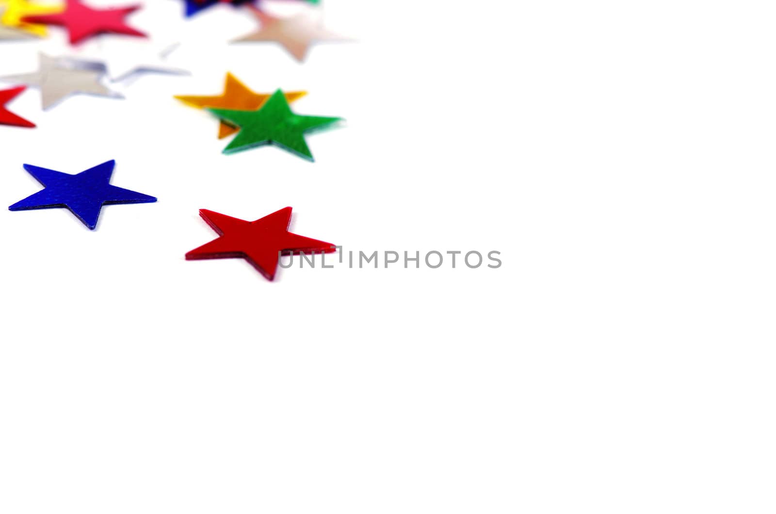 Christmas decoration of colored confetti stars against white background