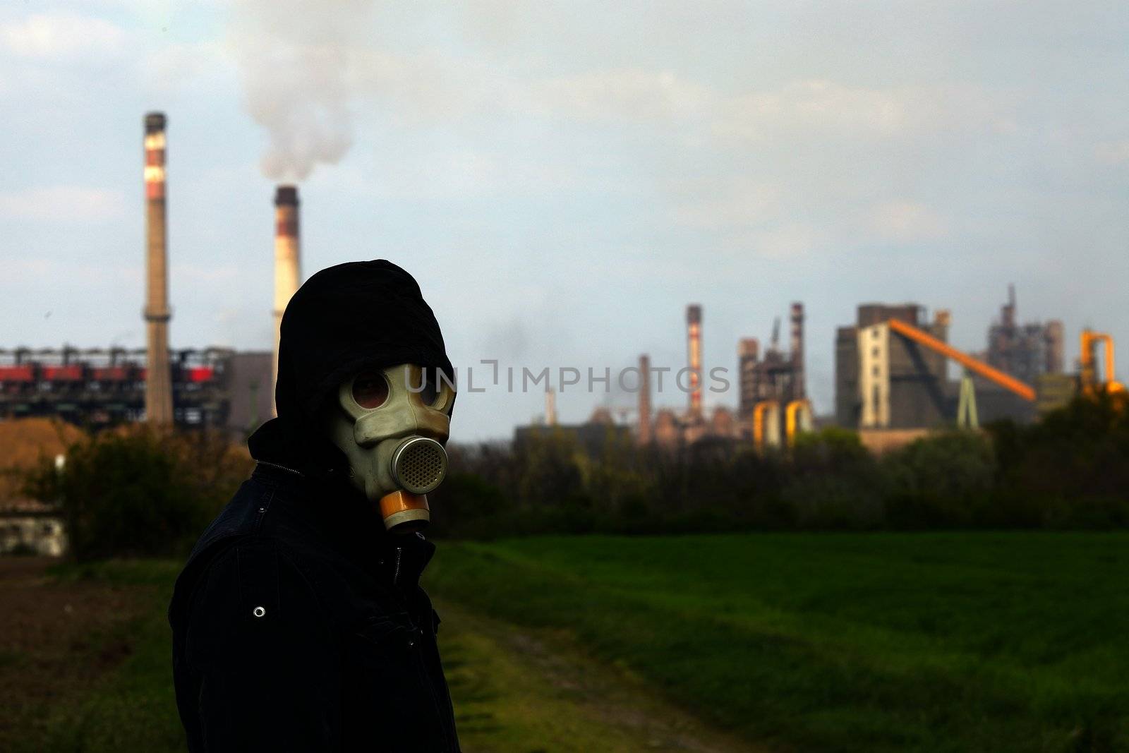 Man in gas mask near a high pollution metal factory