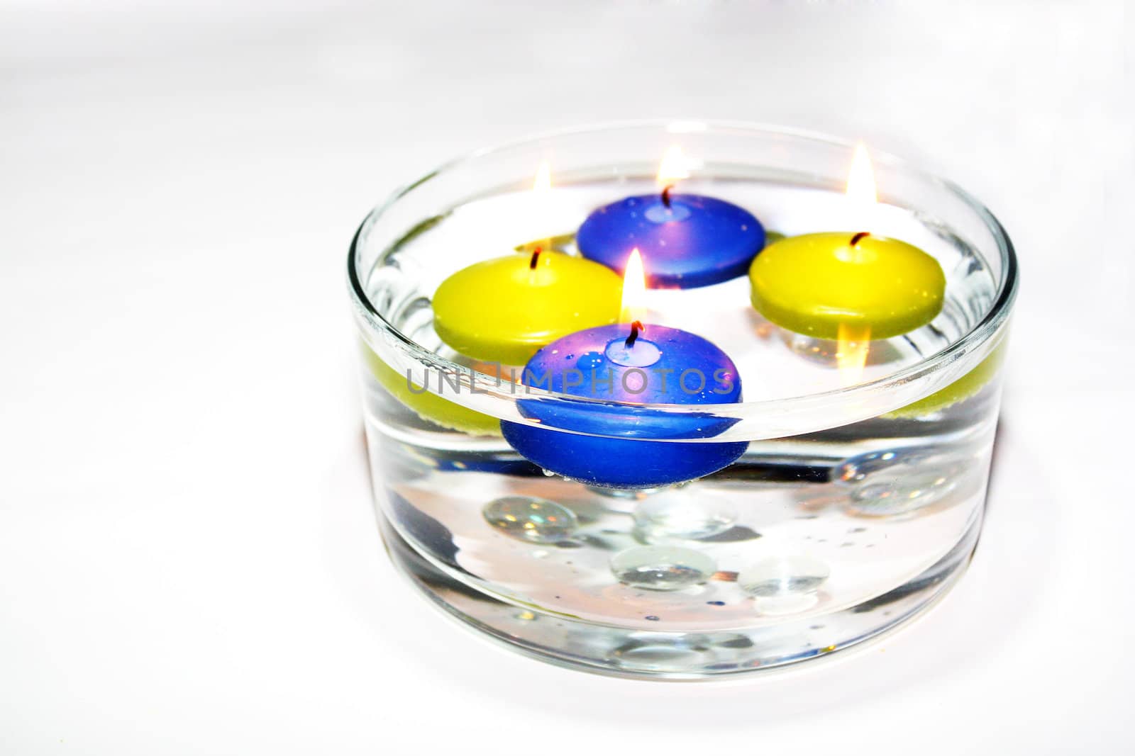 Colored folating candles on water with water drops by valentinacarpin