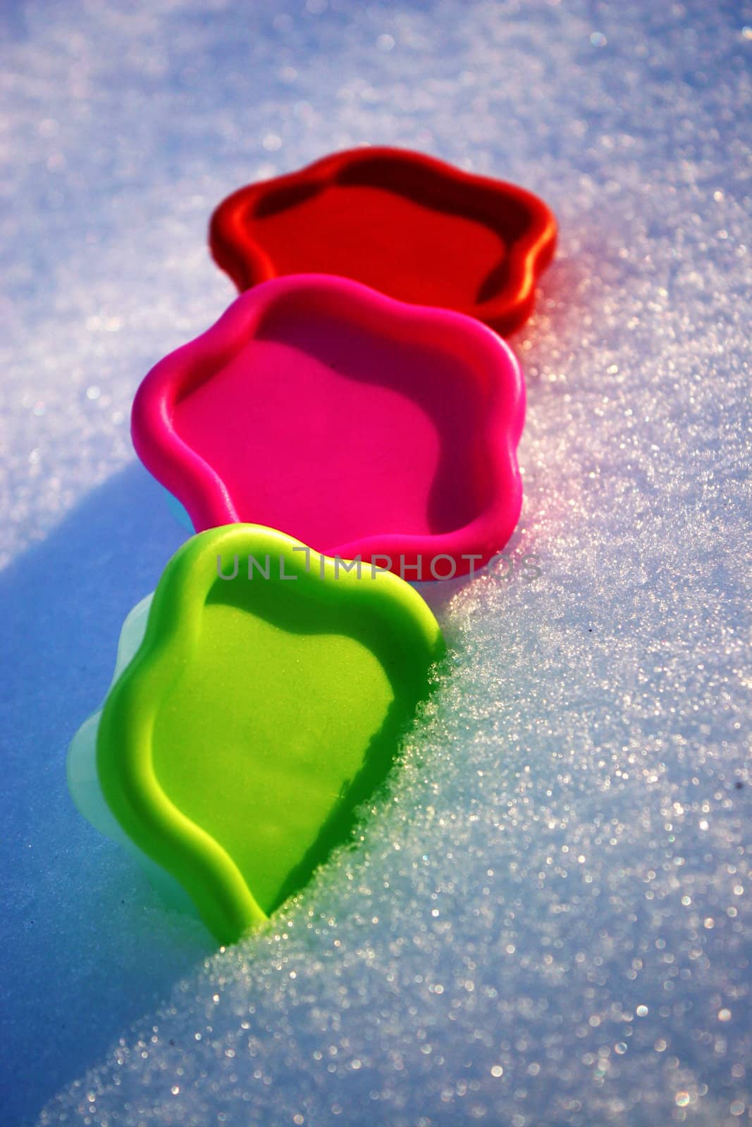 Colored molds green red and pink in the snow in a winter day  by valentinacarpin