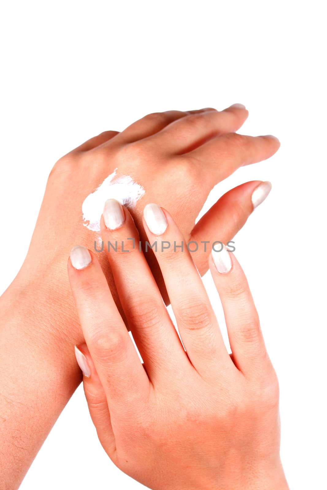 Female applying hand cream on white