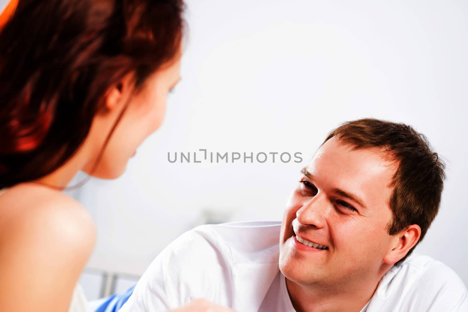 young man lying in bed with his girlfriend, spend time together at home