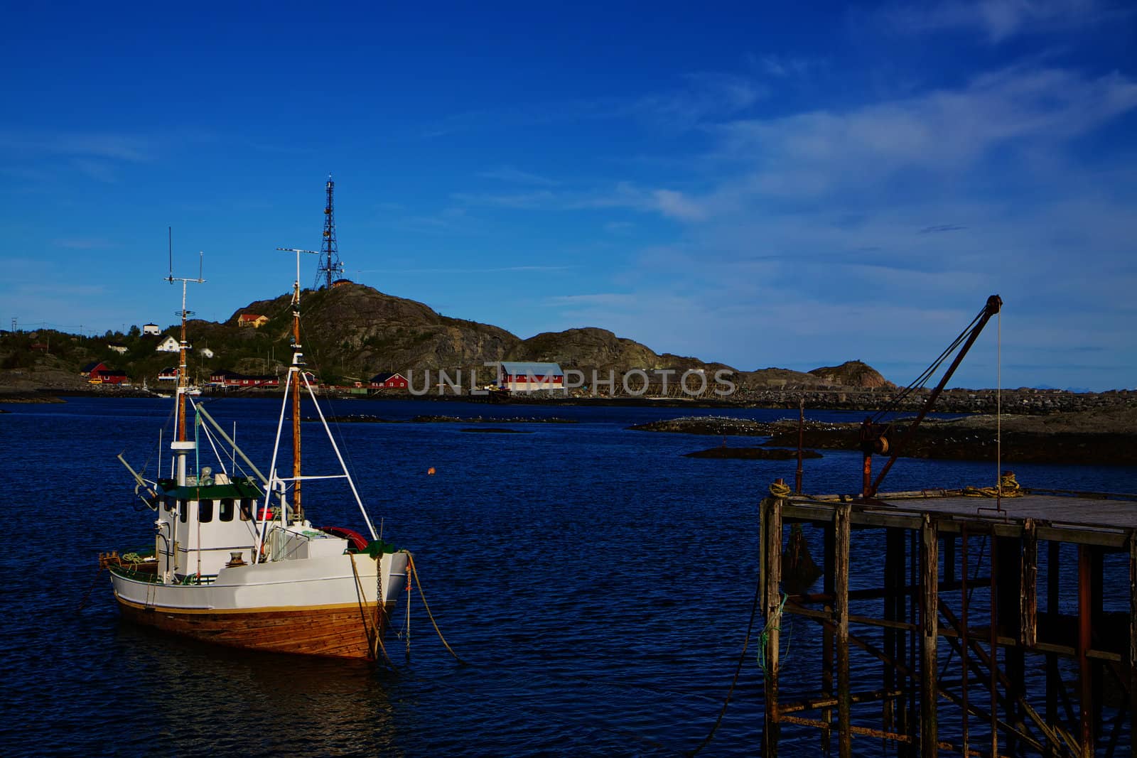 Traditional norwegian fishing boat by pier on Lofoten islands in Norway