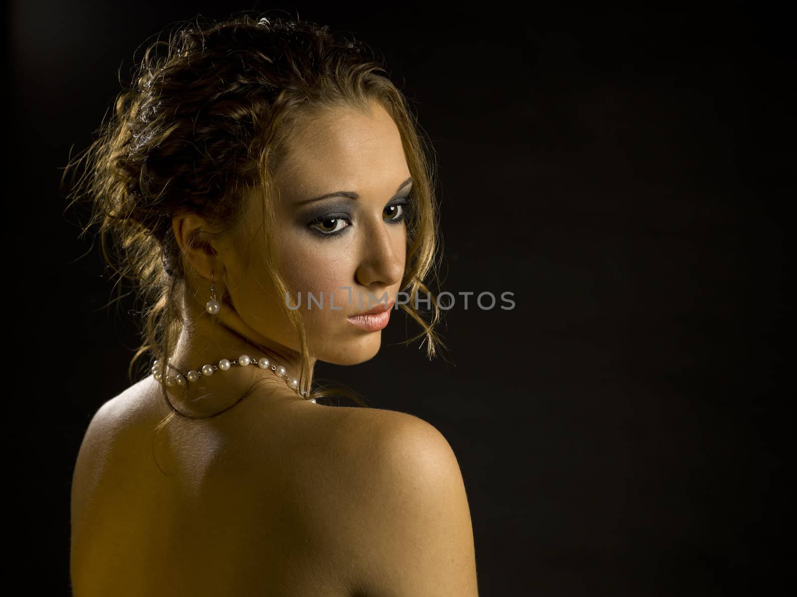 An elegant portrait of a woman on black.                                          Makeup By: Wright Artistry www.wrightartistry.com
