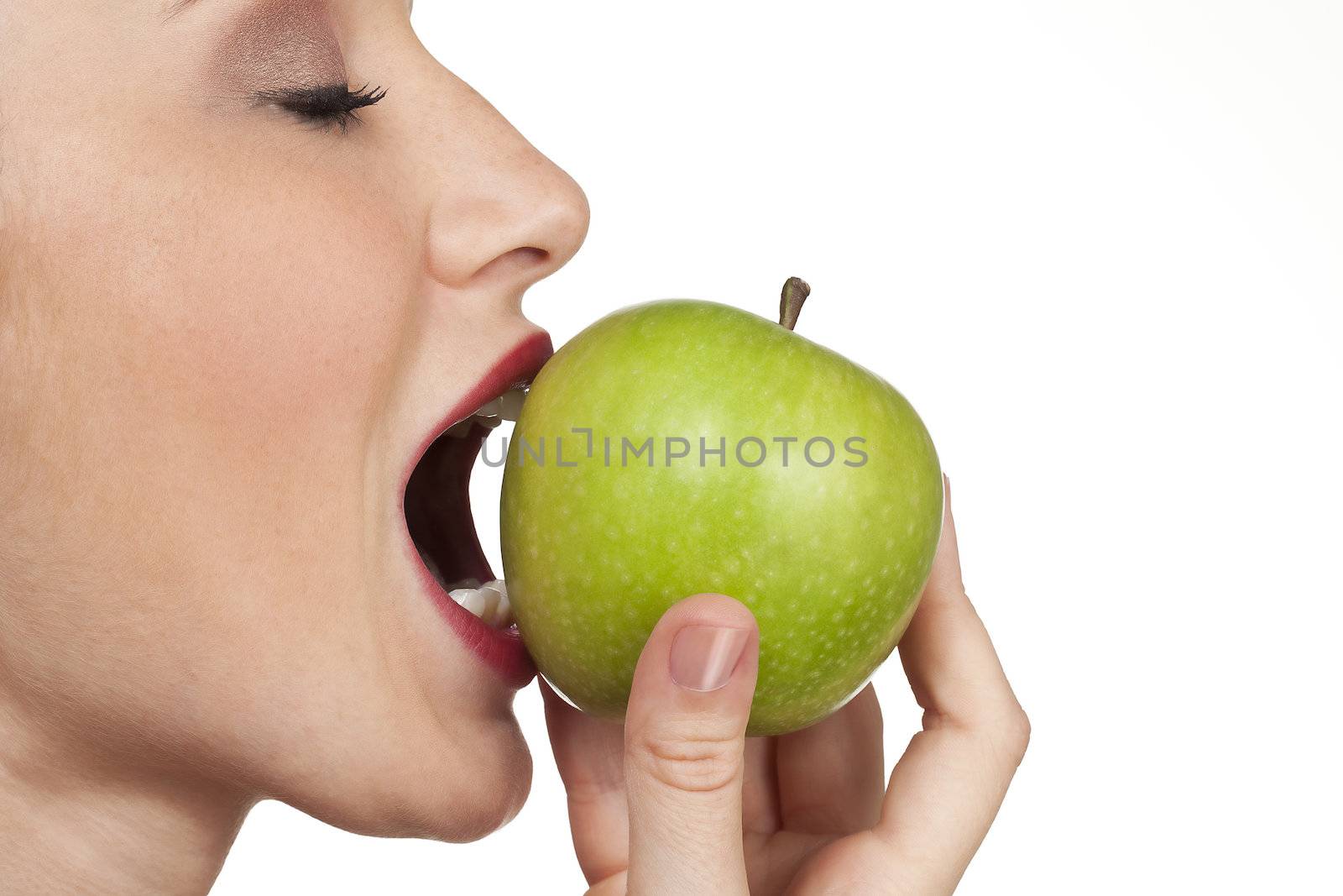 women biting into fresh apple closeup on white background by kozzi