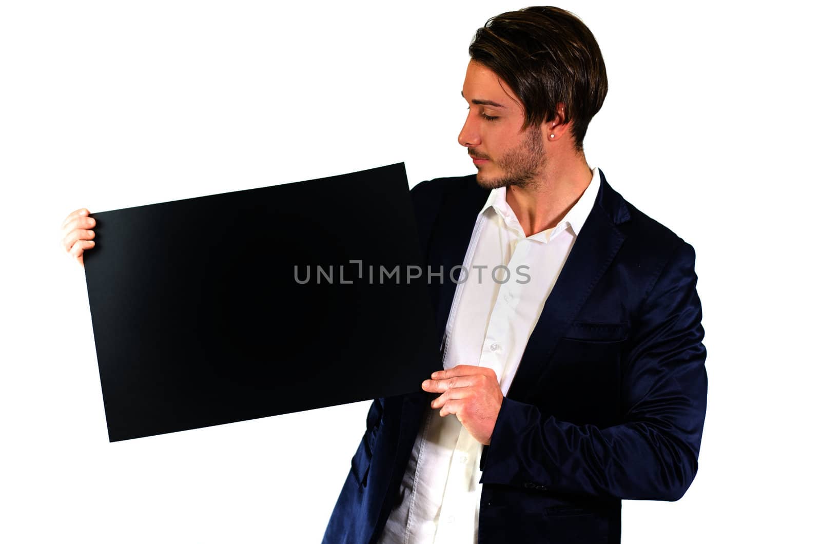 Attractive young man holding and showing empty, blank black board, sign or paper sheet