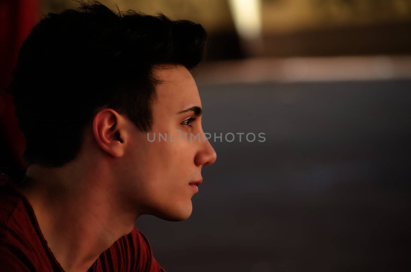 Attractive young man's side view portrait. Profile shot, outdoors