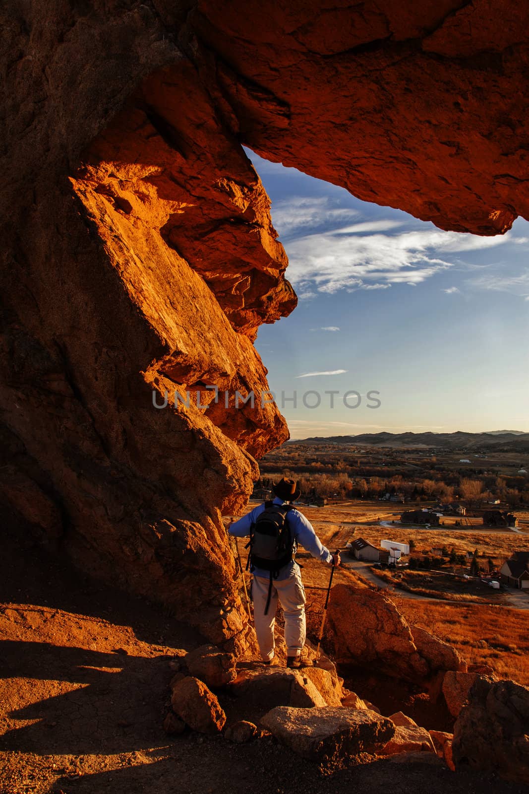 male hiker looking through a keyhole in Devil's Backbone Open Space at foothills of Rocky Mountains near Loveland, Colorado, warm sunset light