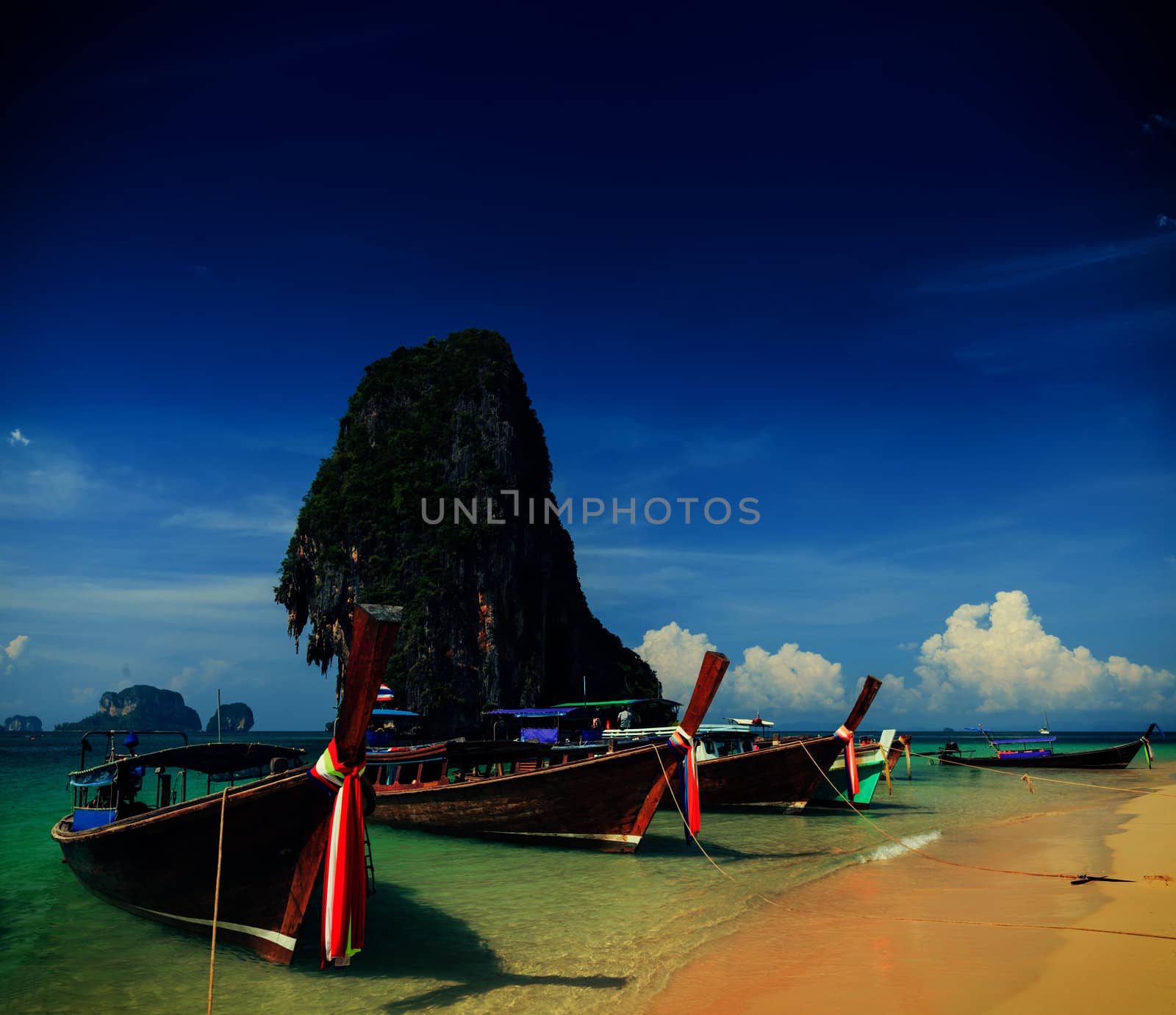 Holiday vacation concept background - Long tail boat on tropical beach with limestone rock, Krabi, Thailand