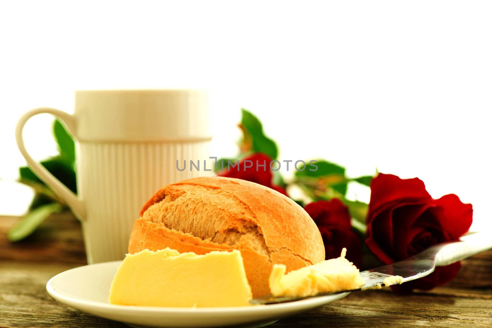 Bread butter and roses on wooden table - romantic breakfast  composition